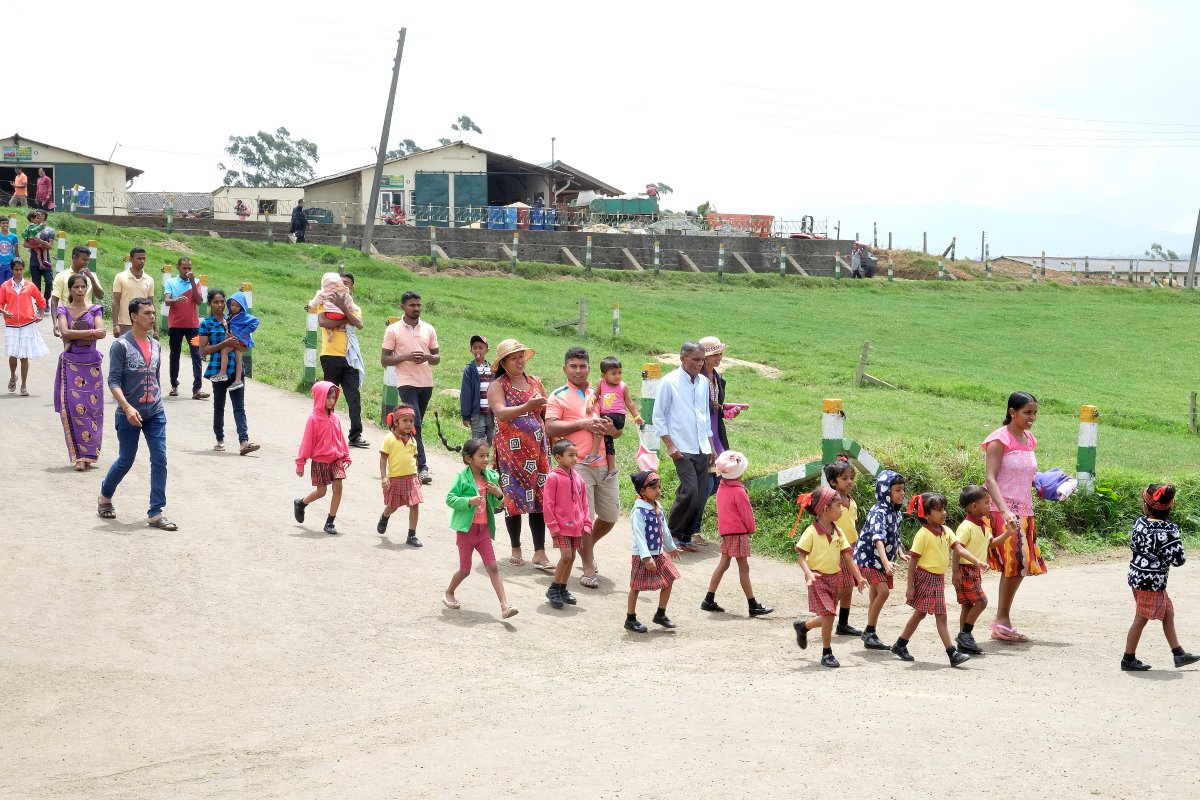Gehuld in kleurrijke kledij zijn deze Sri Lankaanse bezoekers onderweg naar de melkveestal.